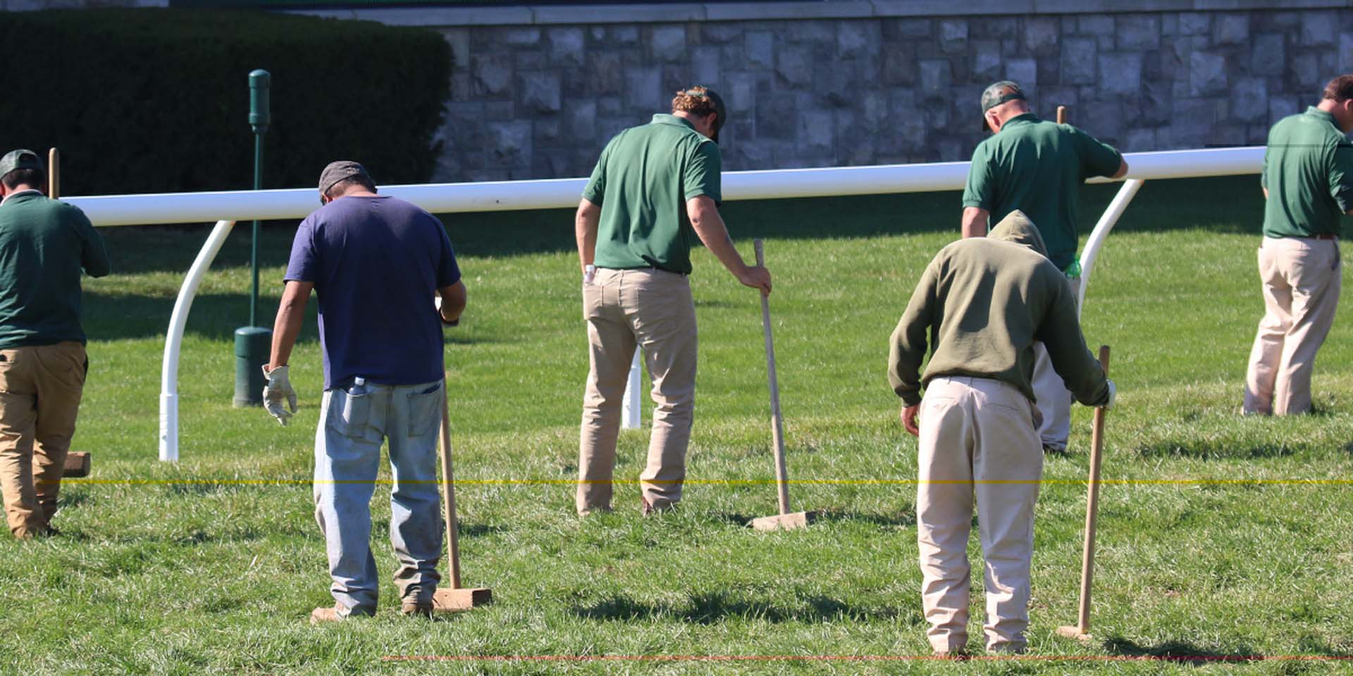 An action shot of Jockeytips team members tamping down turf divots.